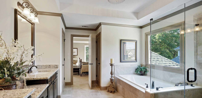owner's bathroom with spa tub, double vanities and large window