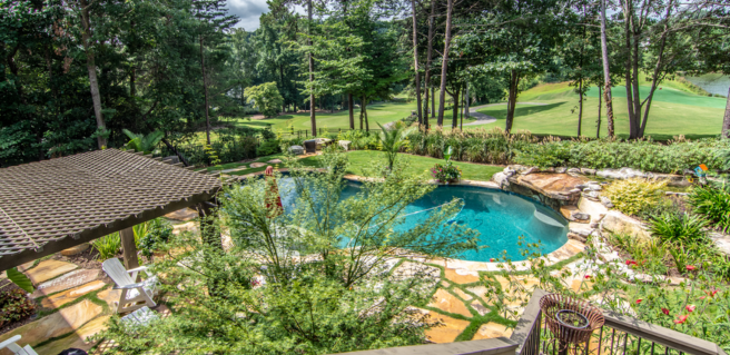 Backyard with pool, stone steps and view of a golf course