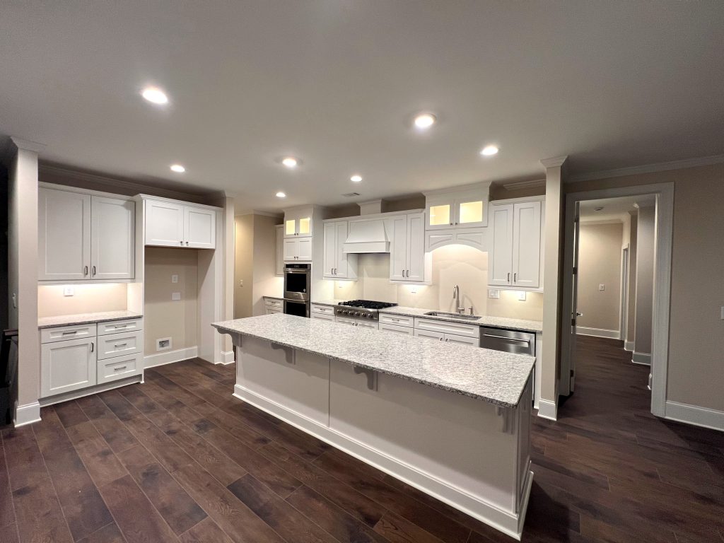 Custom home at the Currahee Club features an all-white kitchen with ample cabinetry and a large kitchen island